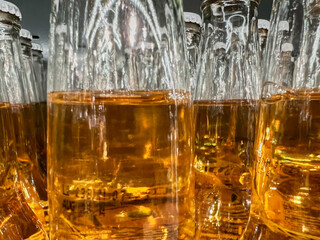 Beer bottles sit side by side in a shop window. A close-up of part of the bottle.