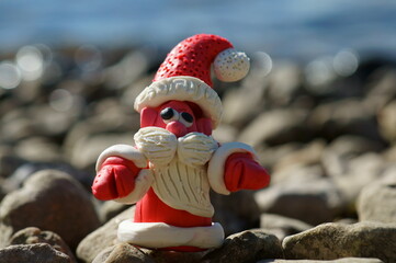 Figure of Santa Claus on the background of the river. Bright sunny summer day. A fairy-tale...