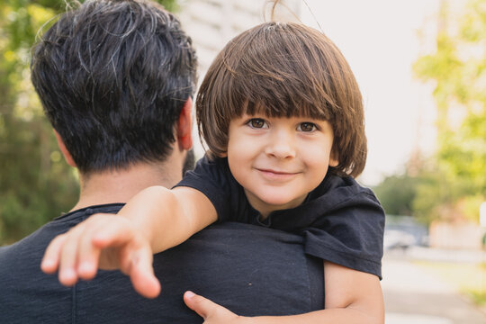 Cute Kid Coming Back From School On The Fathers Shoulder With A Follow Me Hand Gesture