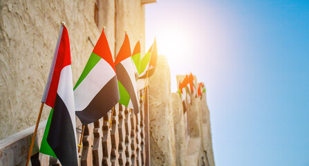 Flags installed in traditional Arabic architecture in Arabian Heritage village, Al Seef Dubai, located in Bur Dubai.