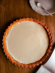 Autumn recipes concept. Composition with a homemade autumn pie, a cookbook and a dessert plate on wooden background. Autumn, fall mock up. Earth tones. Flat lay, top view. 