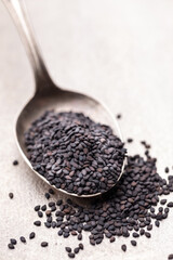 Bio natural black sesame seeds on mettal spoon.
