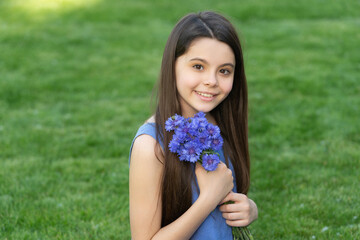 happy teen girl with flowers. pretty girl on grass. cute girl portrait