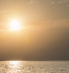 Bright warm orange dawn sun high in the sky and the sea surface of the Black Sea, on a warm summer...