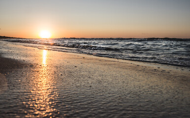 Naklejka premium Evening coast of the Black Sea with warm sunset lighting, sea surf waves in the evening