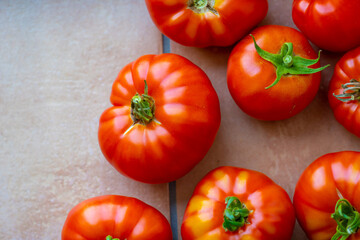 Ripe red tomatoes on a stone floor.