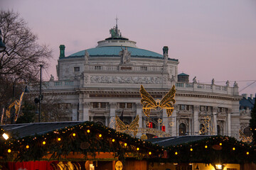 Theatre building in Vienna with Christmas markets stalls in the evening, Austria