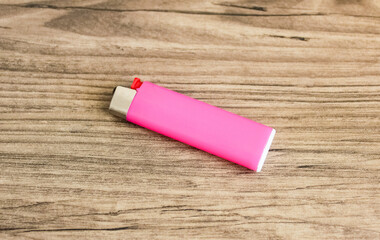 Pink lighter on wooden background