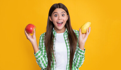 amazed girl with apple and pear on yellow background