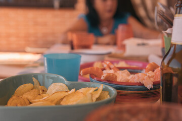 Plate of potato chips, shrimp salad and a beer that have been prepared for a picnic or home birthday celebration.s