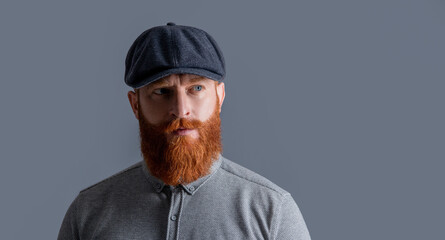 Portrait of Irish guy isolated on grey. Bearded guy with serious face. Unshaven guy with red beard