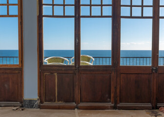 The Mediterranean sea through windows of a derelict hotel