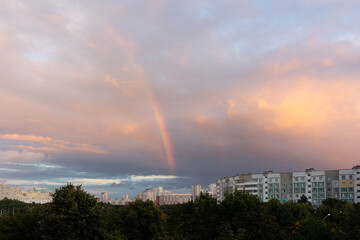 Naklejka na ściany i meble Rainbow in the cloudy sky over the city