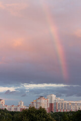 Rainbow in the cloudy sky over the city