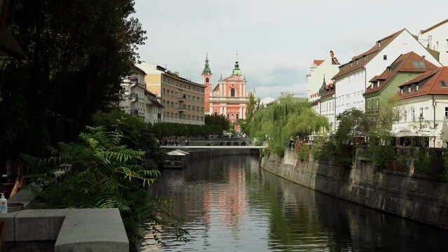 Modern pedestrian bridge Ribja Brv in the center of Ljubljana. Bridge with glass railings over the river Ljubljanica in Ljubljana Slovenia. People walk along the bridge with a beautiful view