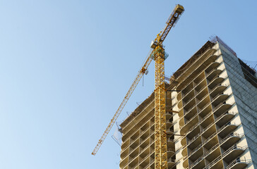 Bottom view of a crane working on the construction of apartments.