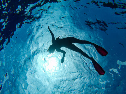 silueta mujer buceando snorkel en el mar azul transparente