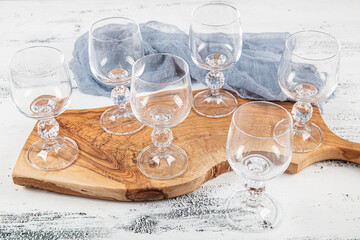 Six Crystal goblet. Set of six empty wine glasses on white wooden background.