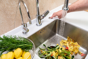 Turning on a disposer in a modern kitchen to remove food waste