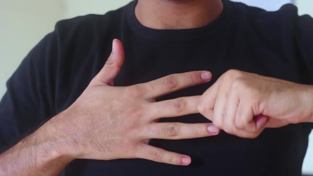 Close-up of man in black T-shirt is cracking his knuckles