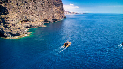 Fotos aéreas de catamarán de recreo en La Playa de Masca y Acantilado de Los Gigantes, Tenerife.