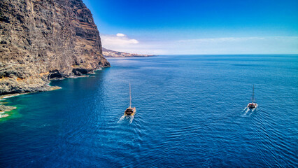 Fotos aéreas de catamarán de recreo en La Playa de Masca y Acantilado de Los Gigantes, Tenerife.