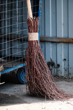 Broom made of tree branches for cleaning on the street, outside the house. Close-up. Selective focus.