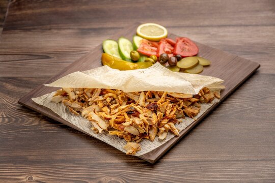 Plate with Shawarma meat and vegetables served on a wooden table