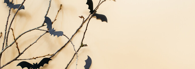 Banner Halloween decorations with bats and branches on pastel beige background. Halloween concept. Flat lay, top view, copy space