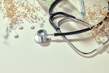 Stethoscope with natural, delicate beige background and props. Health care and medicine concept......