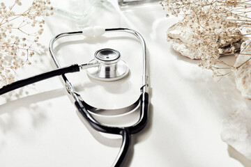 Stethoscope with natural, delicate beige background and props. Health care and medicine concept......