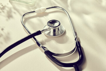 Stethoscope with natural, delicate beige background and props. Health care and medicine concept......