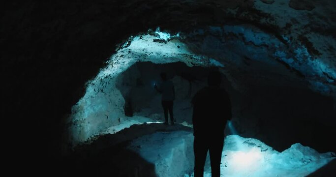 People inside a cave with flashlights.