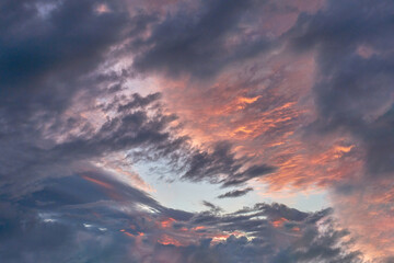 Summer evening sky in the picturesque clouds, lit by the rays of the setting sun.