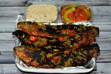 Charcoal grilled mullet fish with parsley and tomato, pickled eggplant aubergine and tahini sauce,...