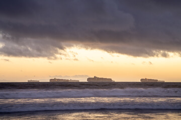 Fototapeta na wymiar Cargo Ships offshore next to Long beach port at sunset