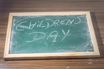 Green chalkboard with the phrase "children's day" written with white chalk