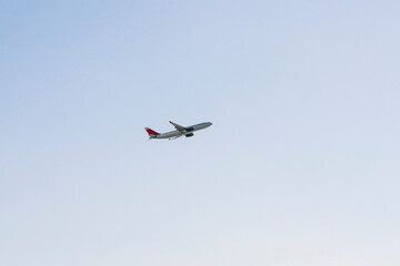 the plane is flying against the blue sky