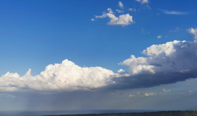 Sopra le grandi nuvole bianche il cielo azzurro e il sole sotto la tempesta