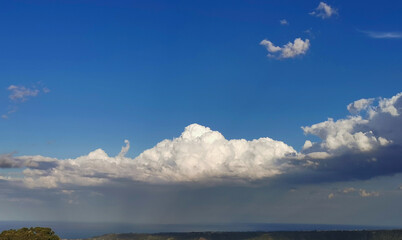 Fototapeta na wymiar Sopra le grandi nuvole bianche il cielo azzurro e il sole sotto la tempesta