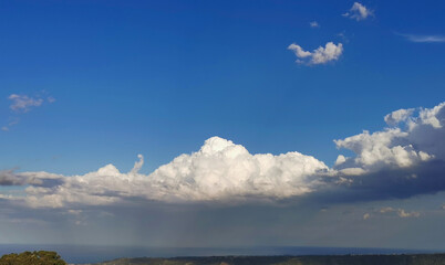 Sopra le grandi nuvole bianche il cielo azzurro e il sole sotto la tempesta