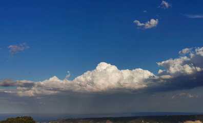 Sopra le grandi nuvole bianche il cielo azzurro e il sole sotto la tempesta