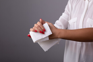 Woman cleaning her hands with white soft tissue paper