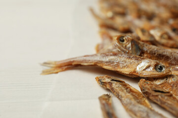 Dried anchovies on white wooden table, closeup. Space for text