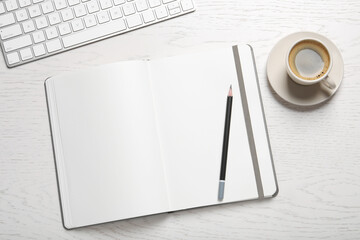 Open blank notebook, pencil, coffee and keyboard on white wooden table, flat lay