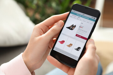 Woman using smartphone for online shopping indoors, closeup