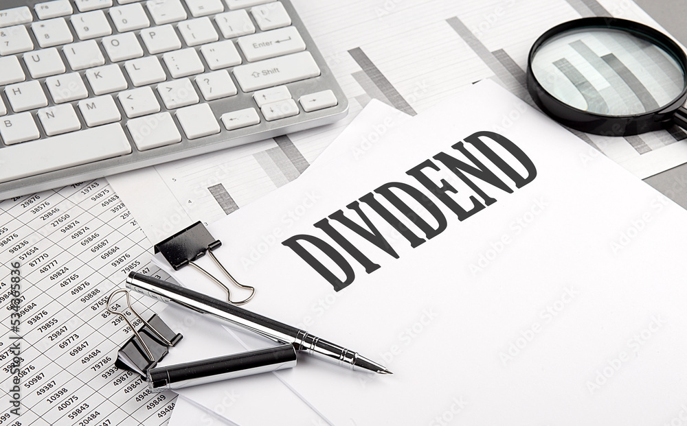 Poster dividend text on paper with chart and keyboard, business concept