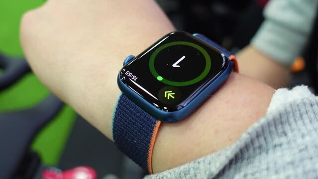 Man turns on timer on smart wristwatch on hand before sports training. Person clicks start button getting ready for exercises in gym closeup