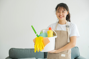 Young woman holding cleaning equipments ready for cleaning.