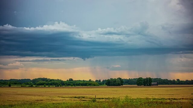 Time Lapse, Dark Rainy Nimbostratus Clouds Spreading Above Colorful Countryside Field With Incoming Rain